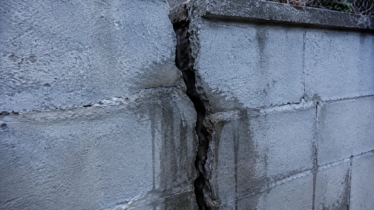 Canalisation en cuivre percée par un foret dans une cloison ouverte, trace d'écoulement sur l'isolant