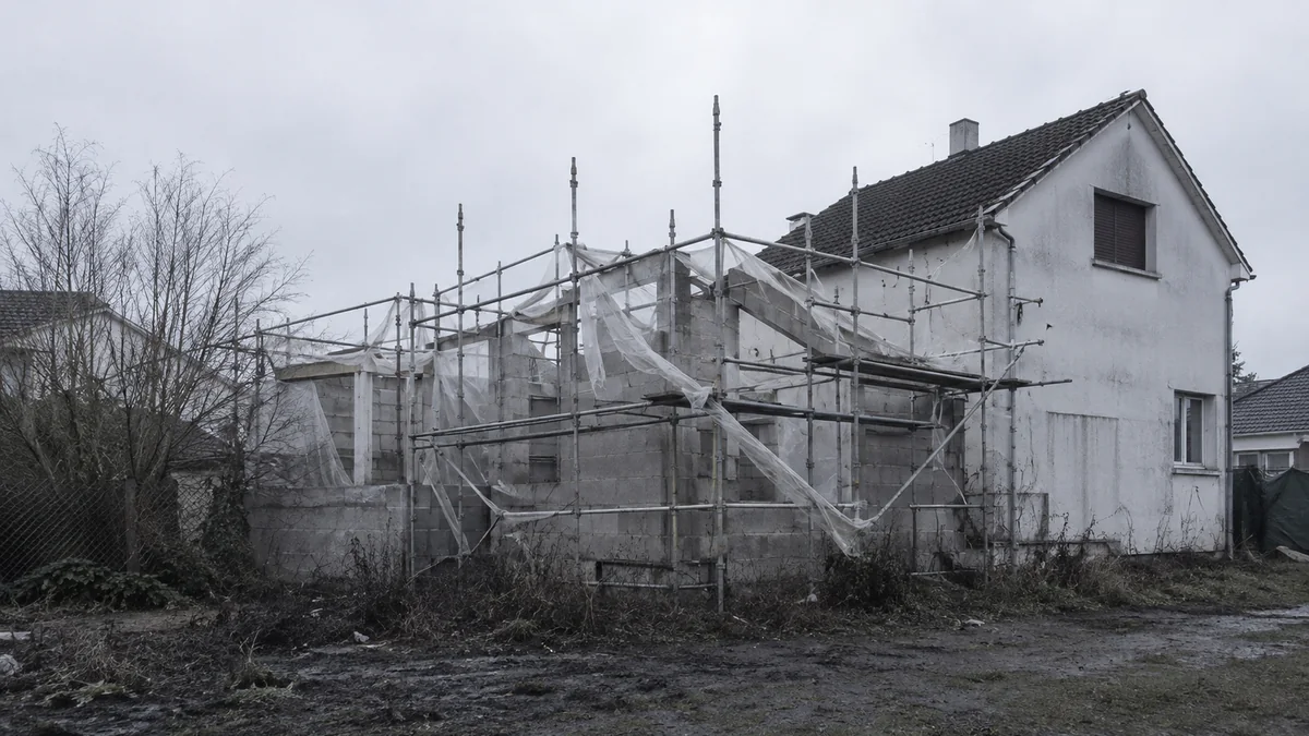 Chantier de construction arrêté en cours de gros œuvre, échafaudage en place et aucune activité sur le site