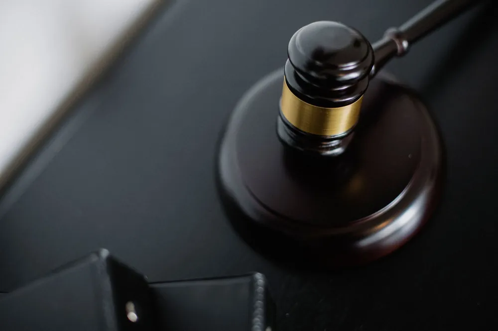 Marteau de juge posé sur un bureau de tribunal, symbole de l'expertise judiciaire en bâtiment